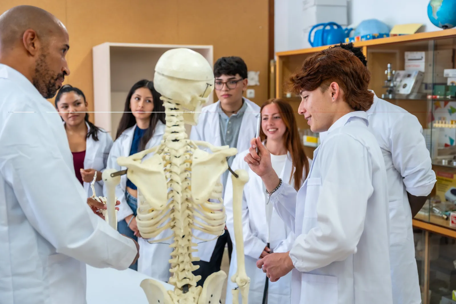 Professor orientando alunos em atividade de anatomia